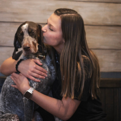 woman and a dog in front of a wood backdrop
