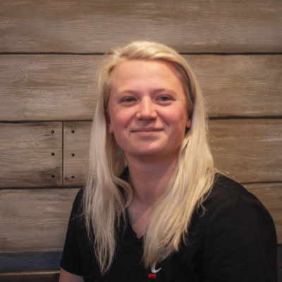 blonde woman in front of a wood backdrop